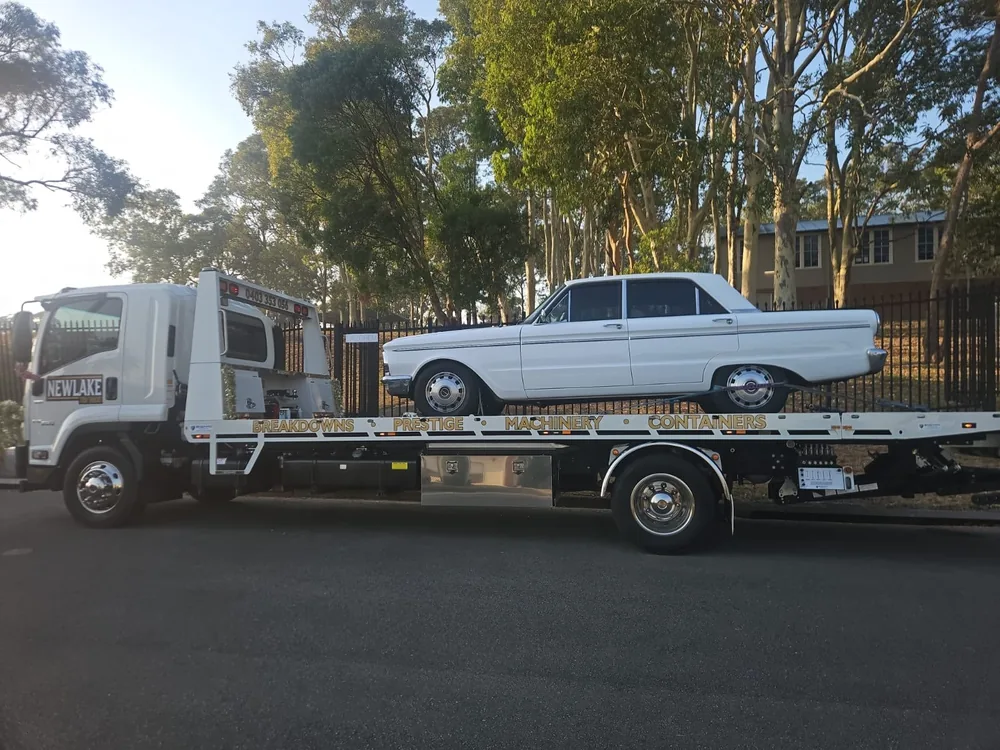 NewLake tilt tray carrying a white classic sedan
